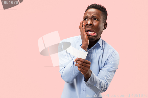 Image of Young boy with a surprised expression bet slip on blue background