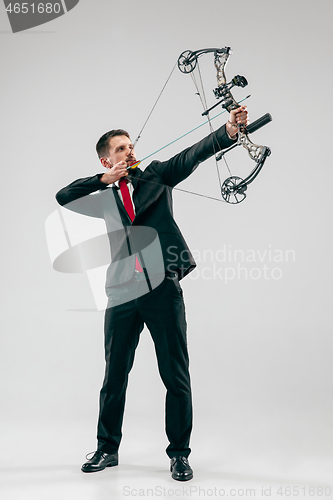 Image of Businessman aiming at target with bow and arrow, isolated on white background