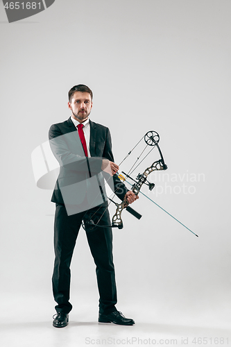 Image of Businessman aiming at target with bow and arrow, isolated on white background