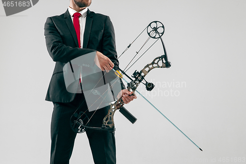 Image of Businessman aiming at target with bow and arrow, isolated on white background