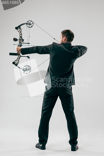 Image of Businessman aiming at target with bow and arrow, isolated on white background