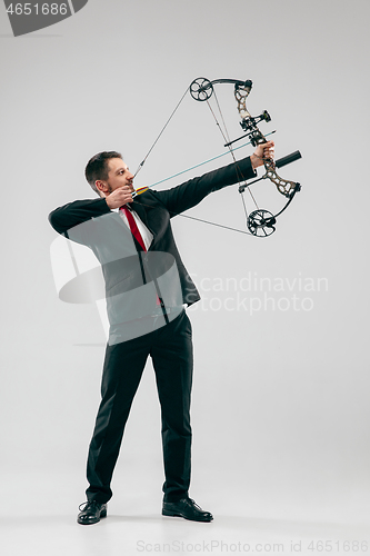 Image of Businessman aiming at target with bow and arrow, isolated on white background