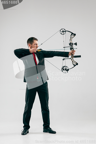 Image of Businessman aiming at target with bow and arrow, isolated on white background