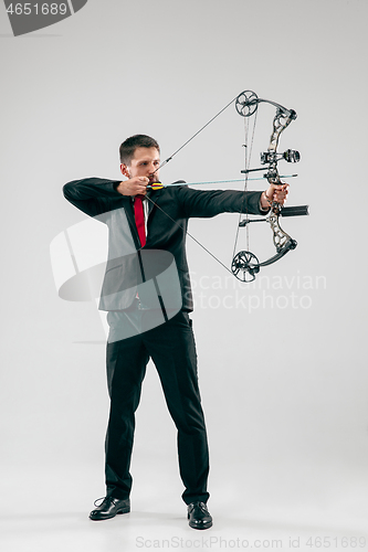 Image of Businessman aiming at target with bow and arrow, isolated on white background