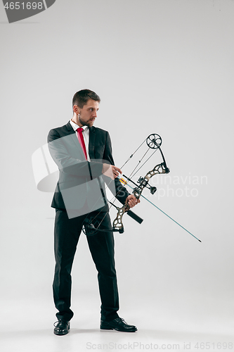 Image of Businessman aiming at target with bow and arrow, isolated on white background