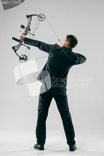 Image of Businessman aiming at target with bow and arrow, isolated on white background