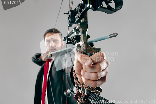 Image of Businessman aiming at target with bow and arrow, isolated on white background