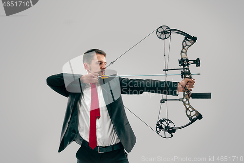 Image of Businessman aiming at target with bow and arrow, isolated on white background