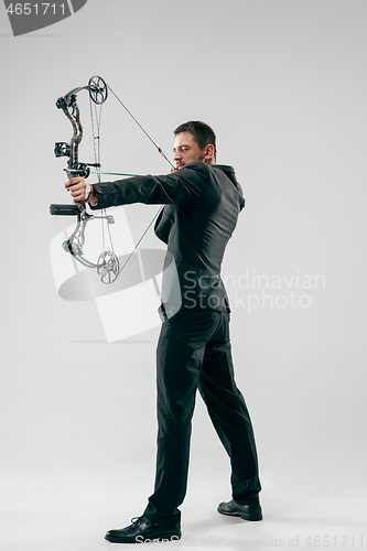 Image of Businessman aiming at target with bow and arrow, isolated on white background