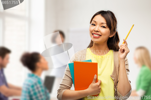 Image of asian student woman with books and pencil