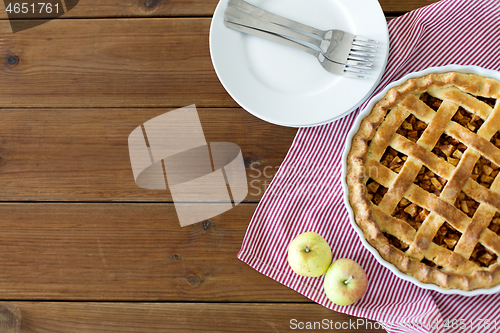 Image of apple pie in baking mold on wooden table