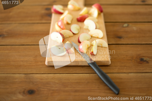 Image of sliced apples and knife on wooden cutting board