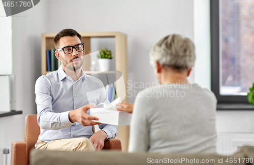 Image of psychologist giving tissues to senior woman client