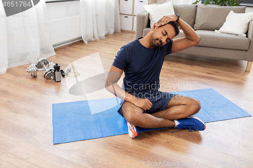 Image of man training and stretching body at home