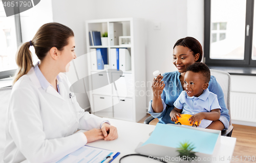 Image of doctor and woman with baby and medicine at clinic