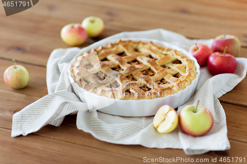 Image of apple pie in baking mold on wooden table