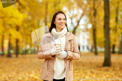 Image of woman drinking takeaway coffee in autumn park