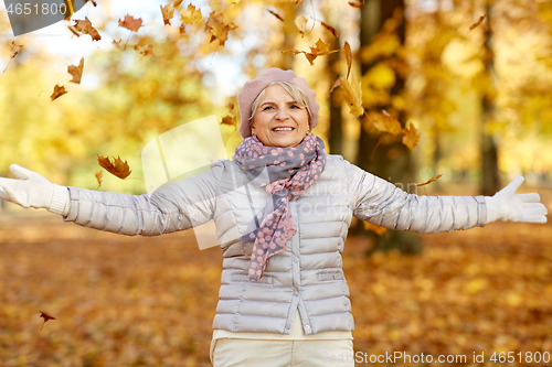 Image of happy senior woman enjoying beautiful autumn