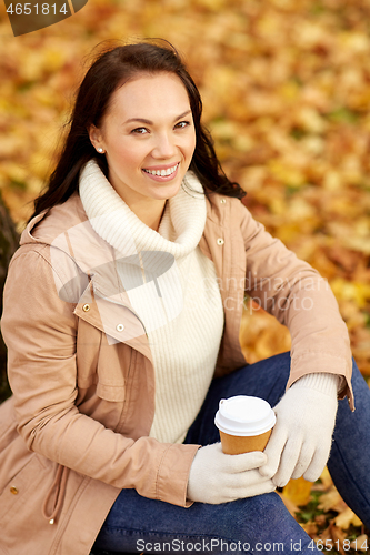 Image of woman drinking takeaway coffee in autumn park