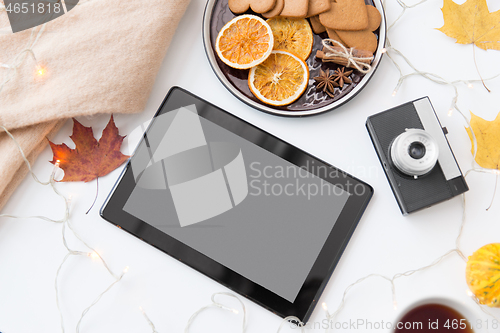 Image of tablet computer, camera, autumn leaves and garland