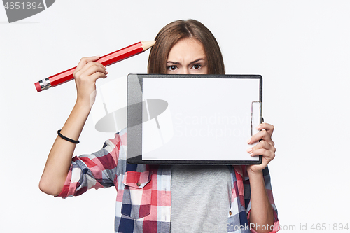 Image of Girl holding big pencil and blank paper sheet