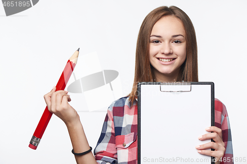 Image of Girl holding big pencil and blank paper sheet on tablet