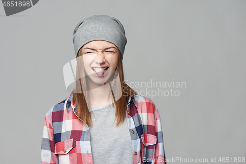 Image of Teen girl screwing up her eyes and showing the tongue