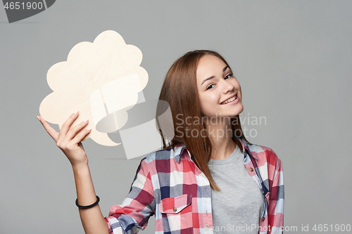 Image of Smiling girl holding thinking bubble looking at camera