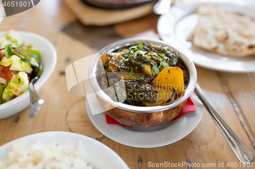 Image of close up of aloo palak dish in bowl on table