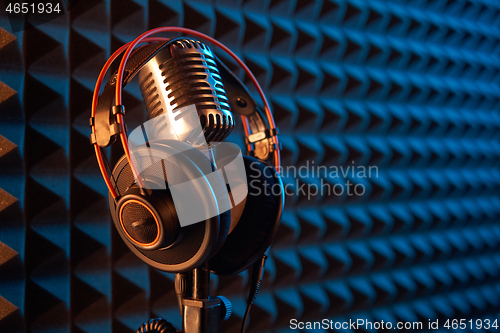 Image of Studio condenser microphone with professional headphones acoustic panel