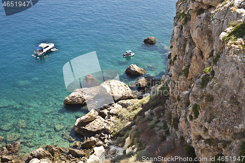 Image of View of the Tremiti Islands. Boats near a rock stone coast.