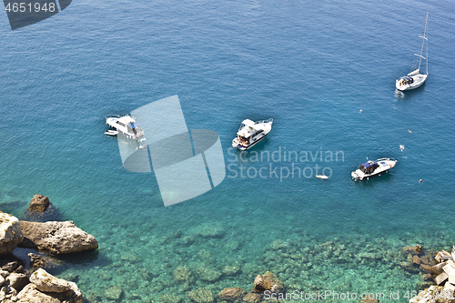 Image of View of the Tremiti Islands. Boats near a rock stone coast.