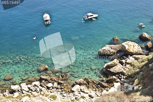 Image of View of the Tremiti Islands. Boats near a rock stone coast.