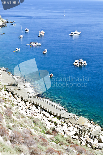 Image of View of the Tremiti Islands. Boats near a rock stone coast.