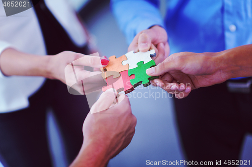 Image of Group of business people assembling jigsaw puzzle