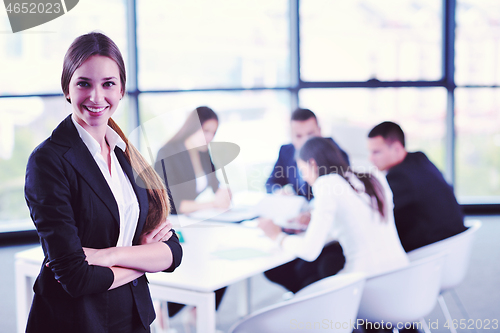 Image of business woman with her staff in background at office