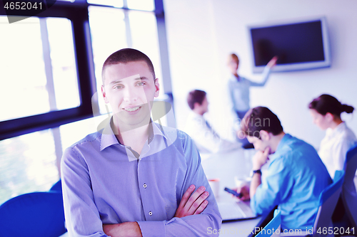 Image of business man  on a meeting in offce with colleagues in backgroun