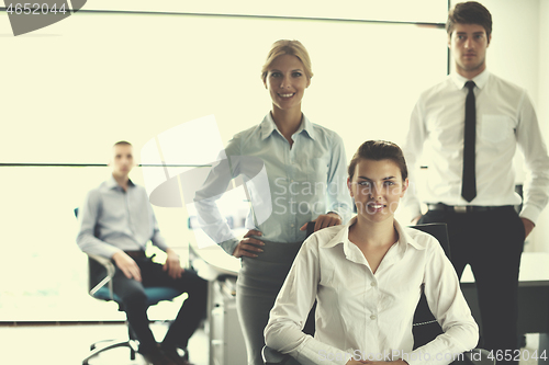 Image of business woman with her staff in background at office