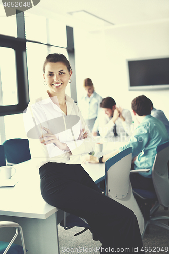 Image of business woman with her staff in background at office