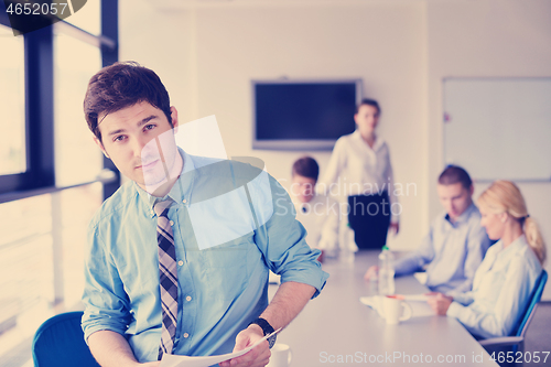 Image of business man  on a meeting in offce with colleagues in backgroun