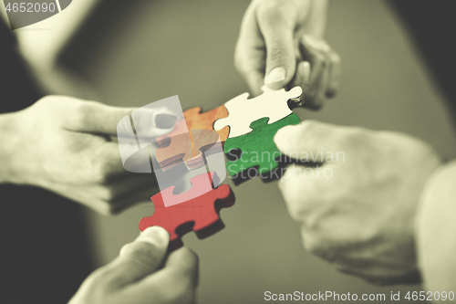 Image of Group of business people assembling jigsaw puzzle