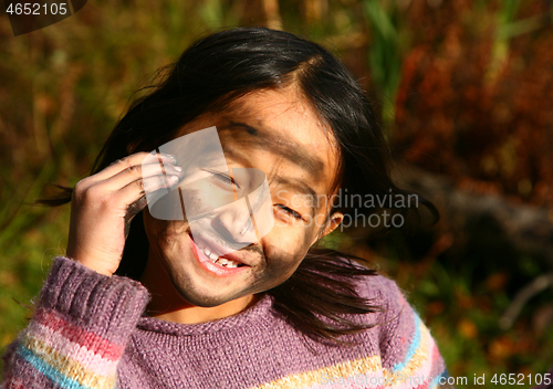 Image of Portrait of a young cute girl looking at the camera putting coal