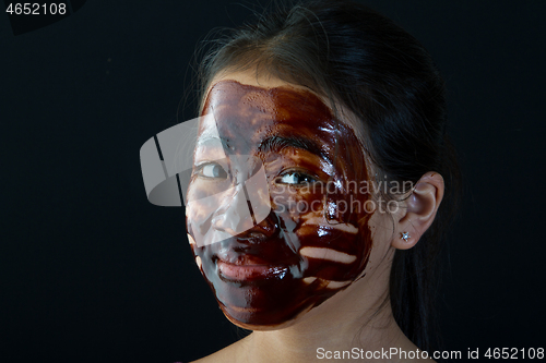 Image of young asian girl having fun with a chocolate mask