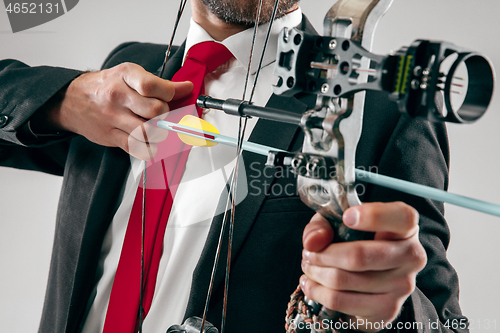 Image of Businessman aiming at target with bow and arrow, isolated on white background