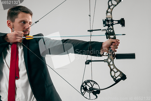 Image of Businessman aiming at target with bow and arrow, isolated on white background