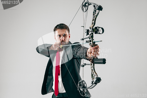 Image of Businessman aiming at target with bow and arrow, isolated on white background