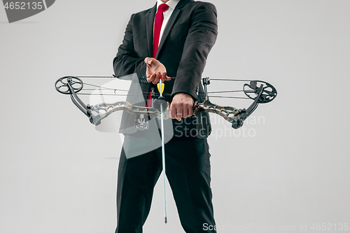 Image of Businessman aiming at target with bow and arrow, isolated on white background