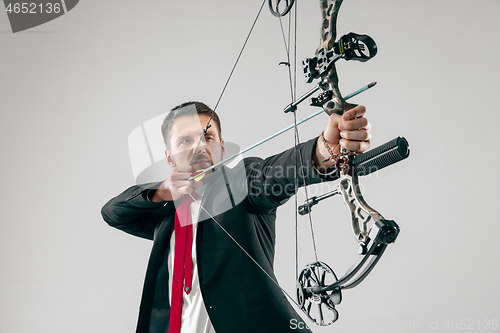 Image of Businessman aiming at target with bow and arrow, isolated on white background