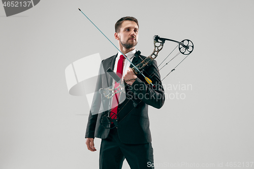 Image of Businessman aiming at target with bow and arrow, isolated on white background