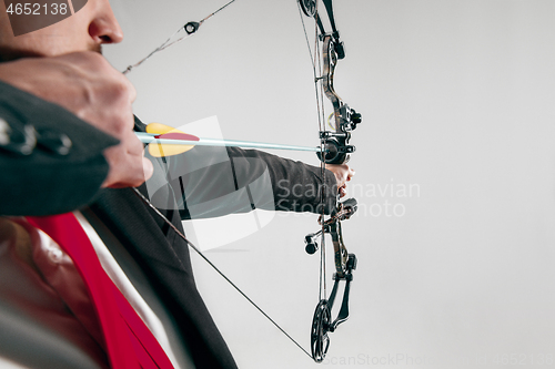 Image of Businessman aiming at target with bow and arrow, isolated on white background